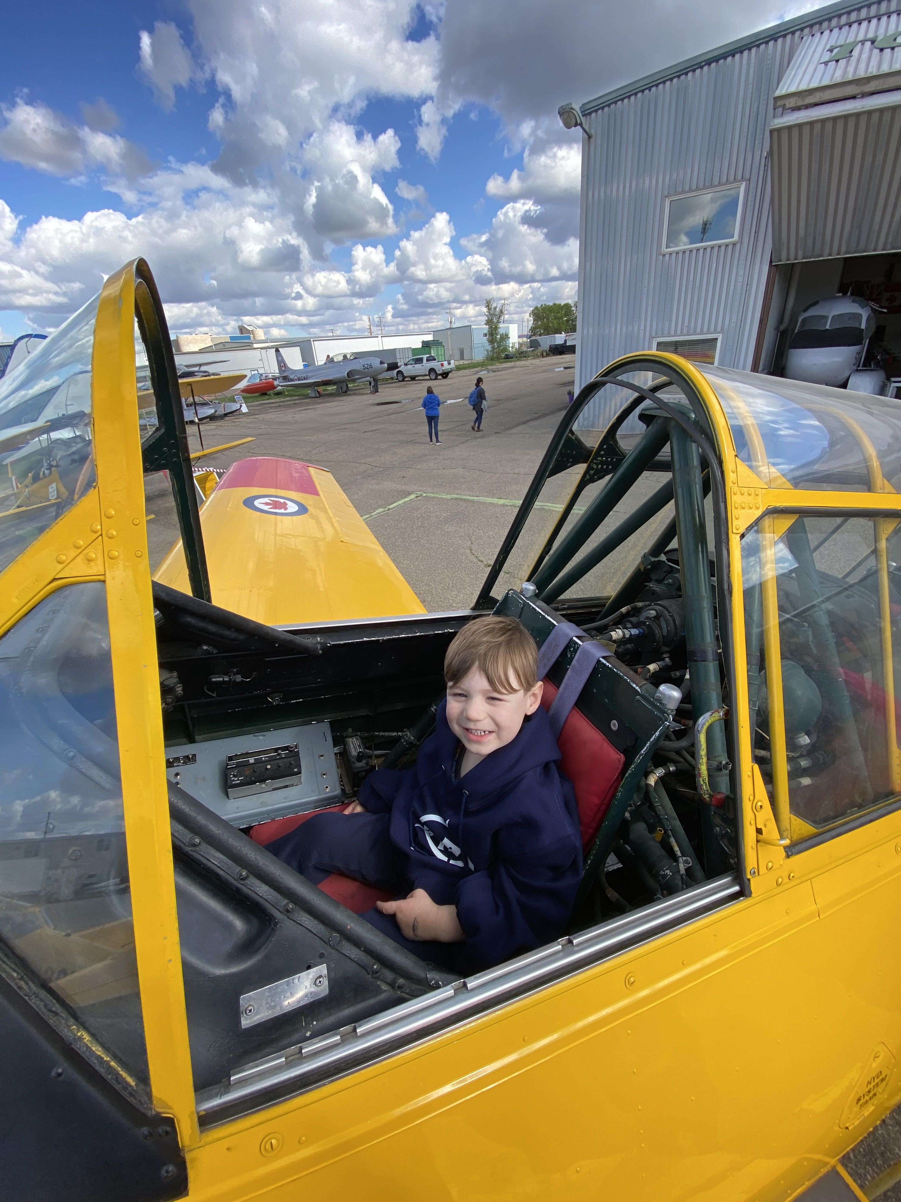 Young person seated at the flight controls of a World War II Aircraft