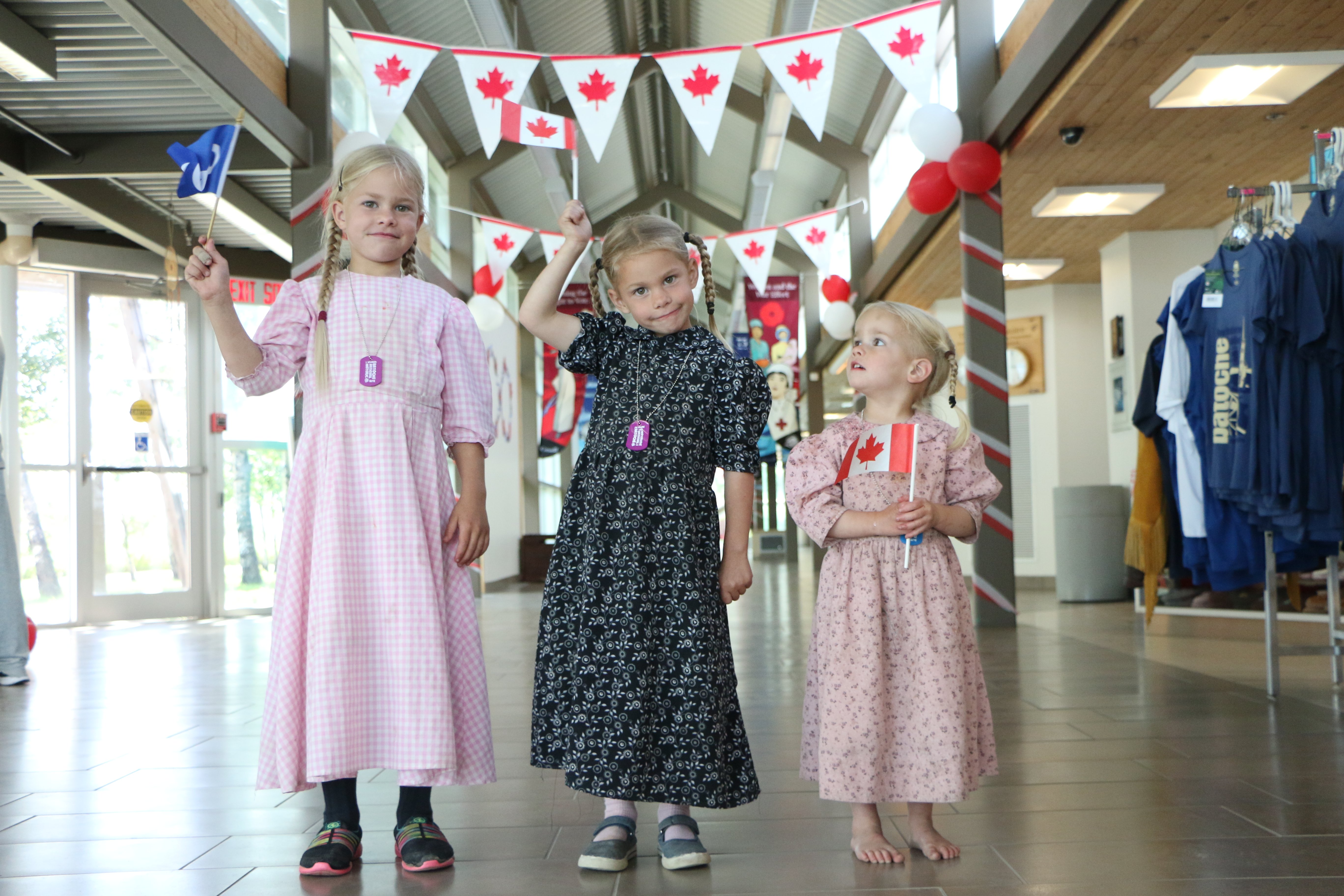 Three youth hold Canada flags.