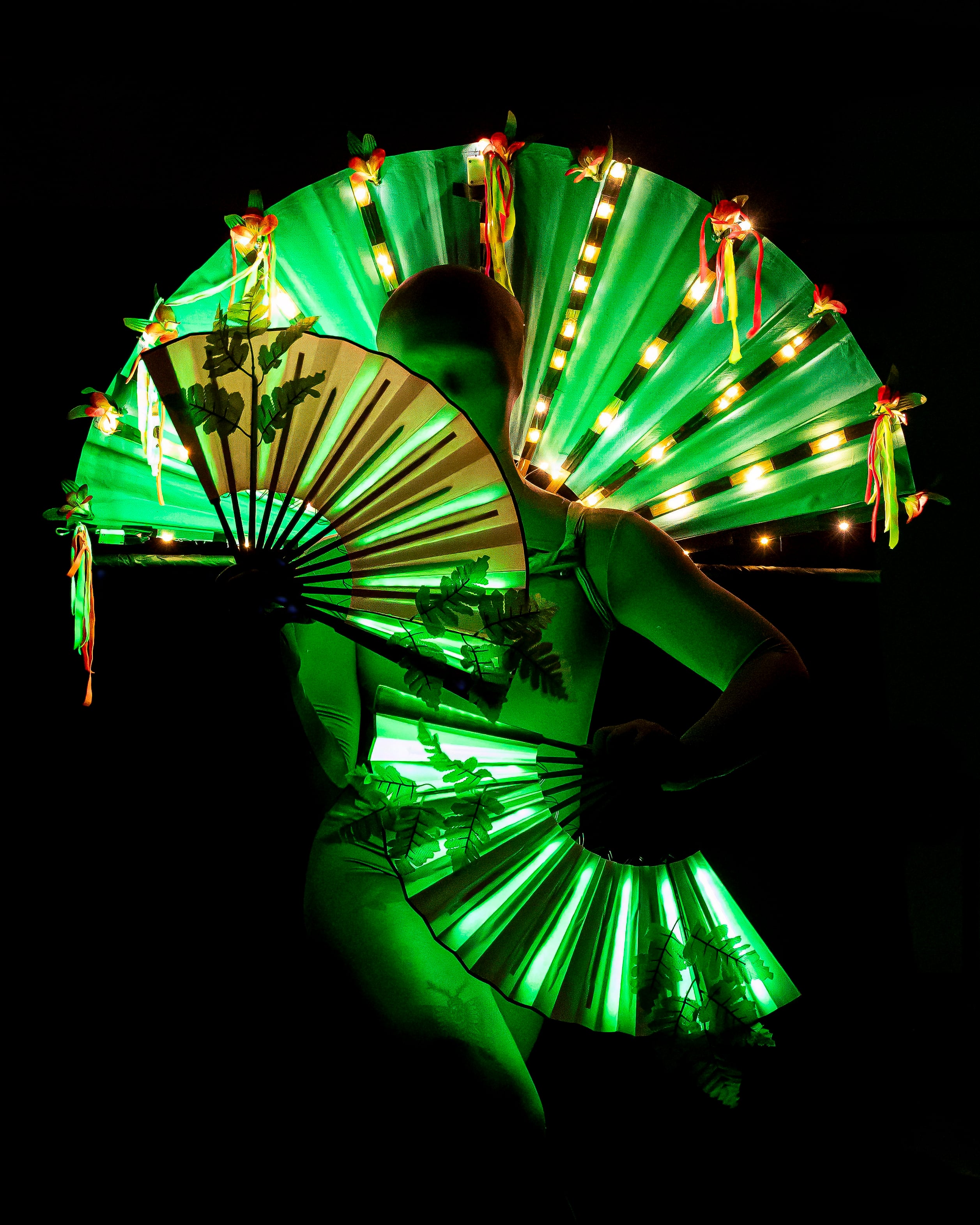 An alien dances with green fans