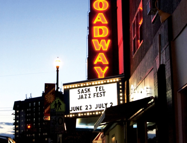 The Broadway theater illuminated at night, advertising the Jazz Fest