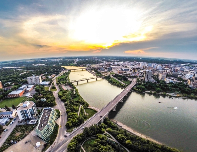 Aerial view of the city of Saskatoon with the river and large buildings in the background