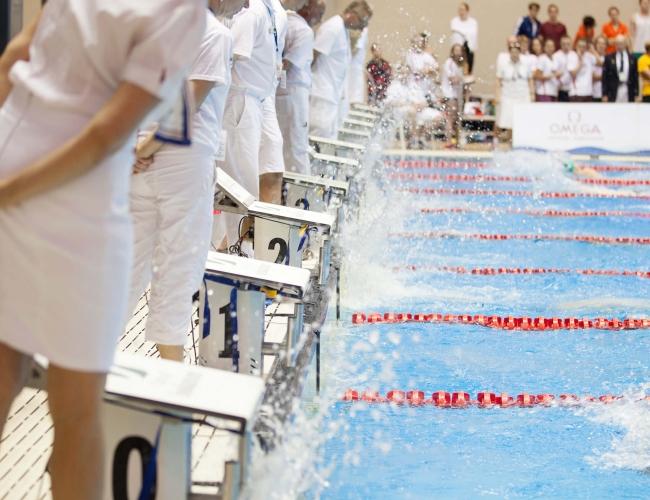 Volunteers at a swimming event looking into the. pool