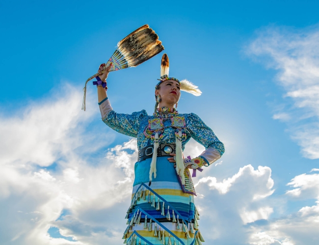 An Indigenous woman in traditional beaded clothing