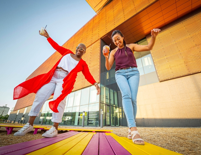 excited couple standing out side of building, sightseeing