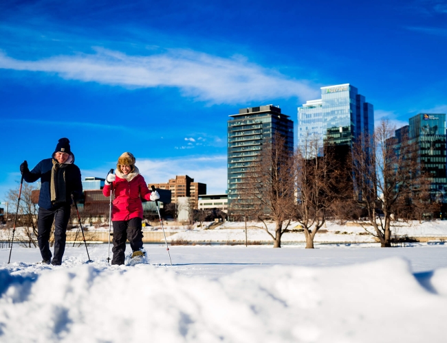 a couple cross country skiing in a city park