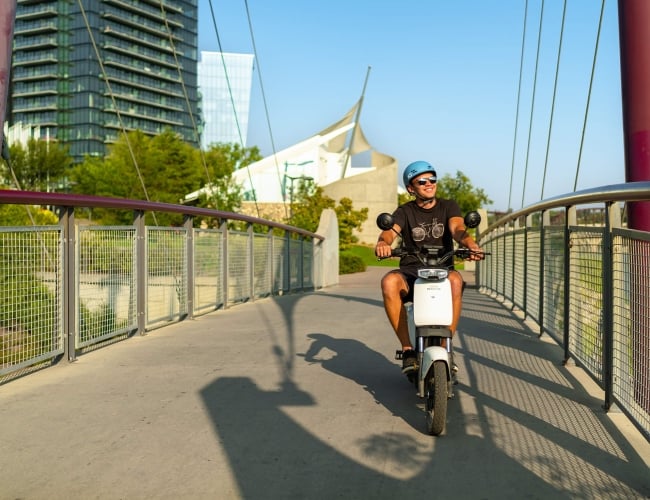 A man riding a bicycle outdoors along a paved path
