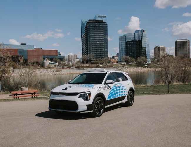 A riide branded car with the city of Saskatoon in the background