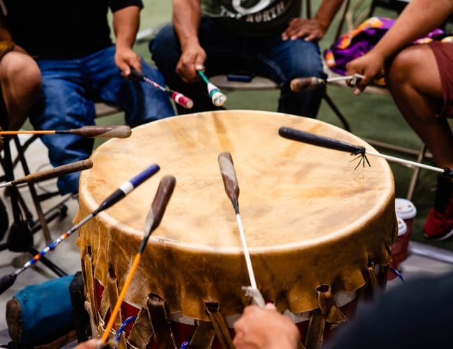 indigenous peoples playing a communal drum