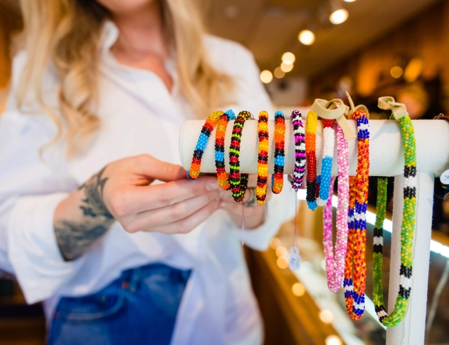 A woman looking at beaded bracelets in a retail store
