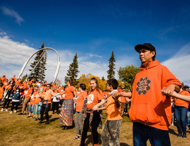 indigenous peoples wearing branded "rock you roots" shirts