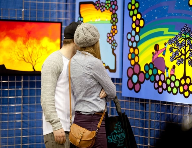 a couple looking at a large colourful painting