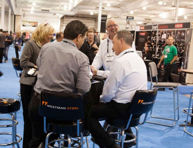 Individuals meeting in a convention setting around a small table