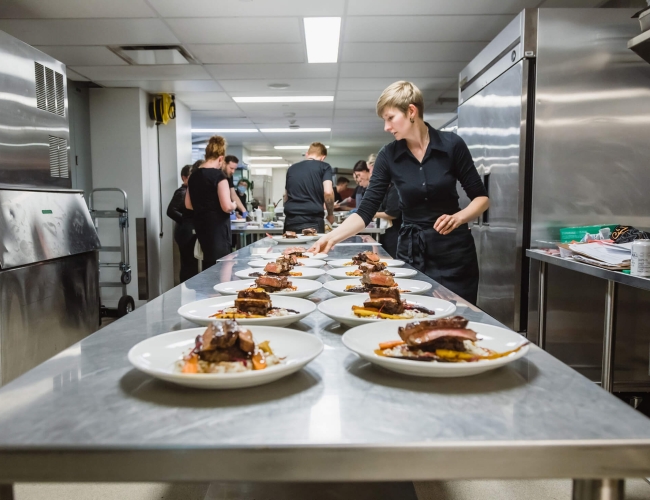 Prep kitchen with plates of food laid on counter