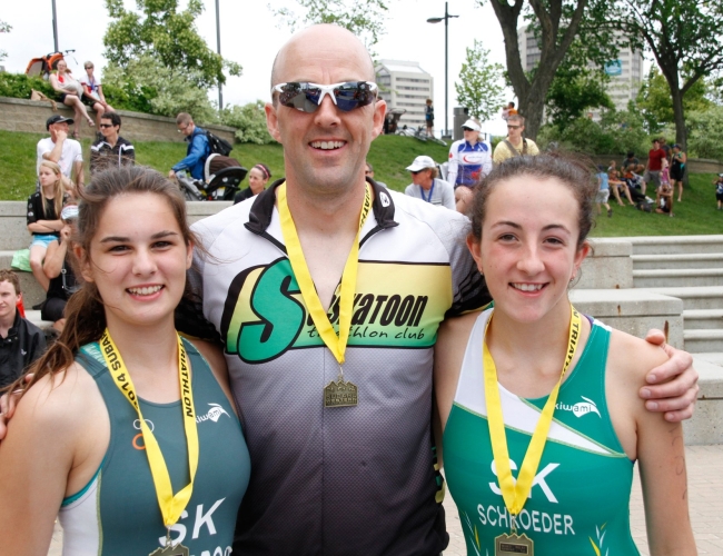 three individuals with medals around their necks in running clothing