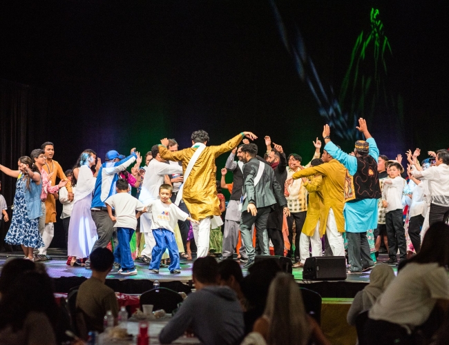 Individuals dancing on stage in colourful clothing