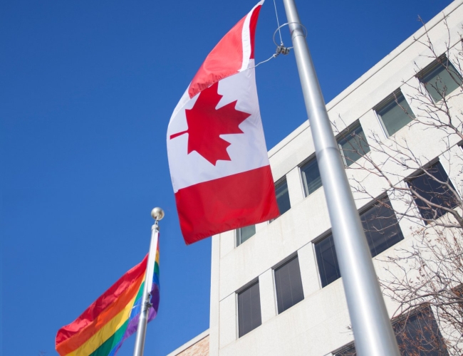 Building with a Pride and Canadian flag flying outfront
