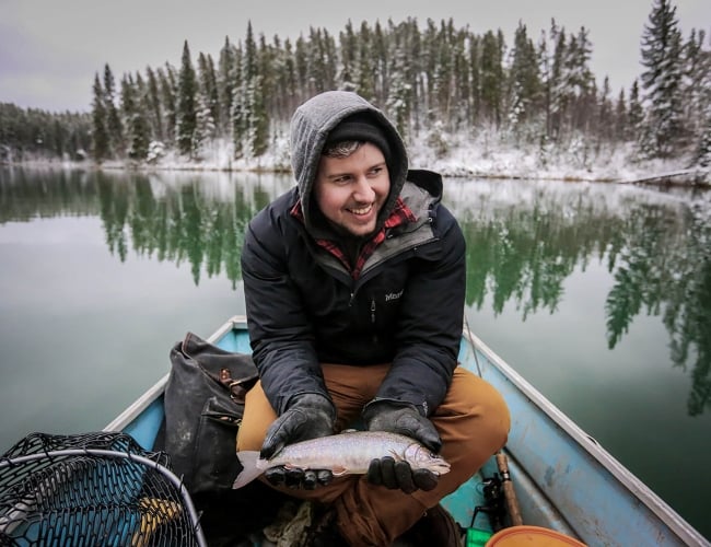 man holding fish in boat 
