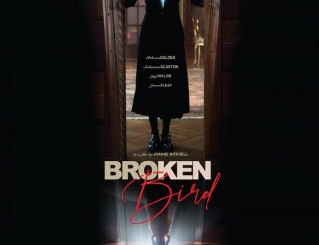 Image from the movie Broken Bird. Image shows a woman standing in a coffin silhouette doorway.