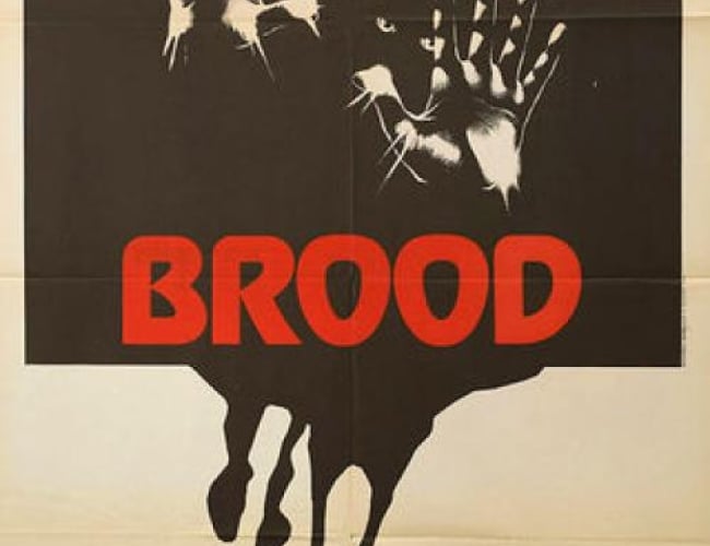Image from the movie; the brood. Hands are pressed up against the picture with light at the fingertips and creepy eyes in the background. 