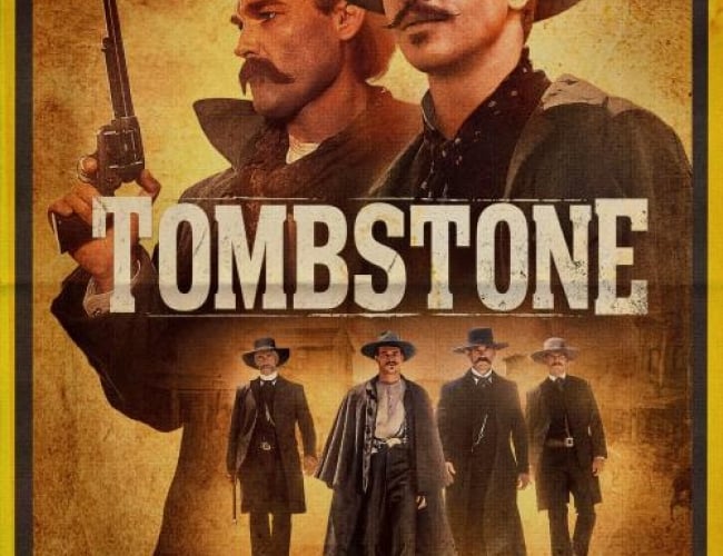 Image from the film Tombstone. Shows 4 people dressed up as cowboys in the wild west with moustaches and guns.