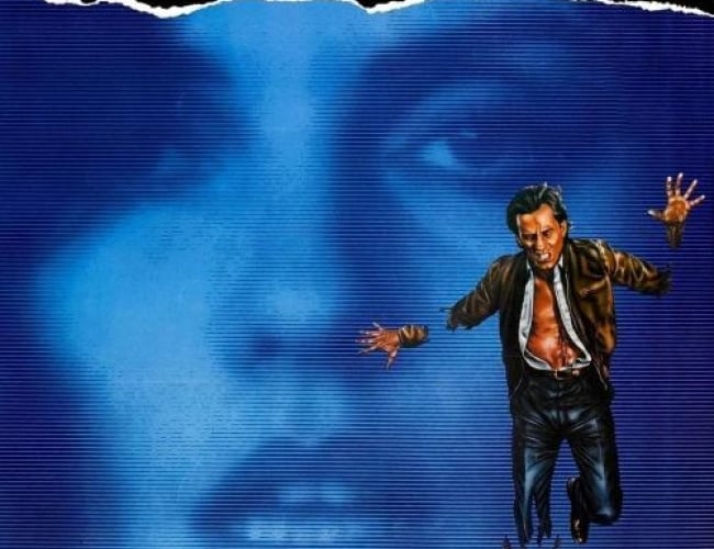 Image from the movie Videodrome. Shows the face of a woman in the background with a blue tv static filter and then a man with his shirt ripped open looking as if he is trying to escape from the tv.