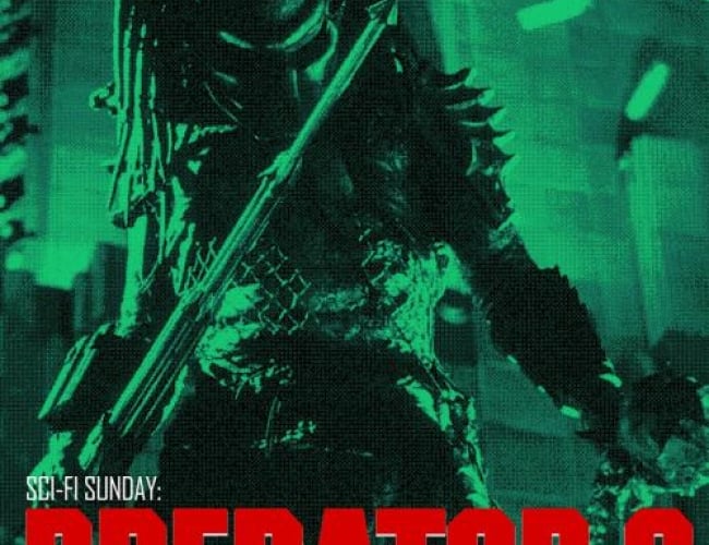Image from the movie predator 2; the predator is standing holding a harpoon gun, ready to attack. Image is black and green.