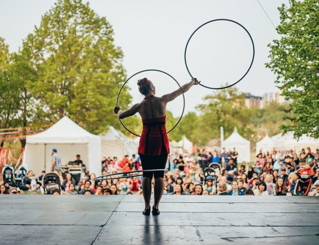 performer on stage with hula hoops in front of crowd