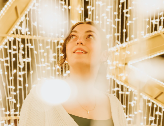 Woman surrounded by glowing lights.