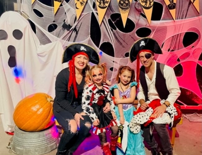 Family seated posing for a photo in Halloween costumes