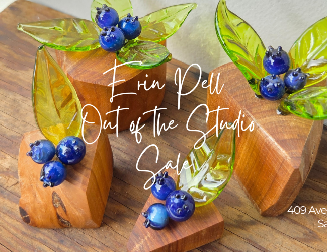 glass blueberries with transparent green leaves on orangey wood bases with event detail written in white script