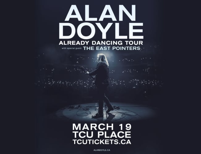 A picture of a man on stage with a guitar, a spotlight on him.