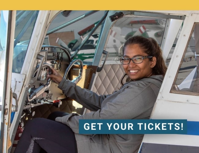 Young woman sitting at the flight controls of a Cessna 337 twin engine aircraft