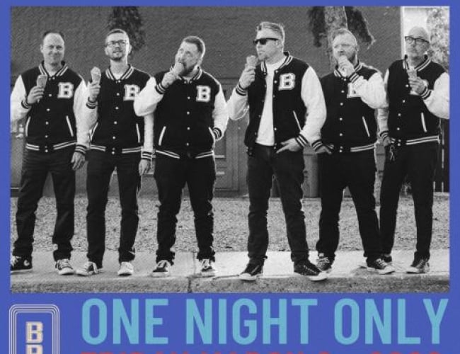 Image of 6 men standing in matching outfits (letter jackets) eating ice cream. 