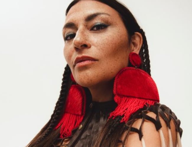 Image of singer Elisapie standing there, with a neautral face.