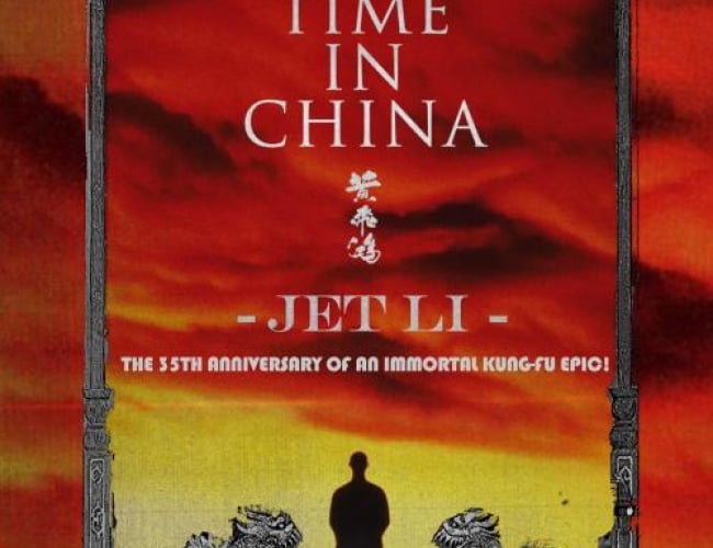 Image of red and yellow sunset with someone standing there in the distance. 