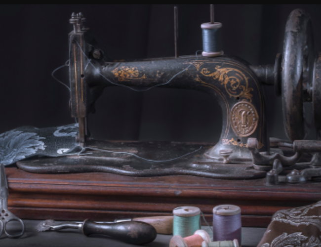 vintage sewing machine sitting on a table with thread and scraps of cloths