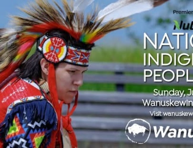 A promotional banner for National Indigenous Peoples Day at Wanuskewin Heritage Park. The image features a dancer in vibrant traditional regalia with a feather bustle and beaded headdress, captured during a cultural performance. Text on the right reads: “National Indigenous Peoples Day, Sunday, June 21, 2026, Wanuskewin Heritage Park. Visit wanuskewin.com for details.” The Nutrien logo appears as the Premier Partner, alongside the Wanuskewin logo. The background shows an outdoor setting with a wooden fence 