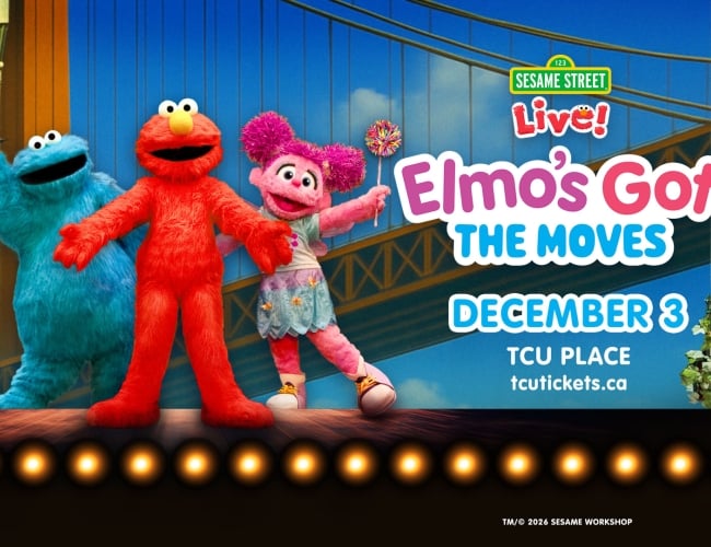 An image of Elmo, Cookie Monster, and Zoey from Sesame Street on a stage.