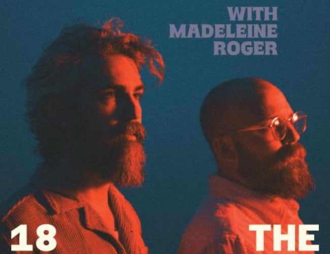 Image of the singer duo The Bros Landreth, baked in orange light and looking off to the distance. 
