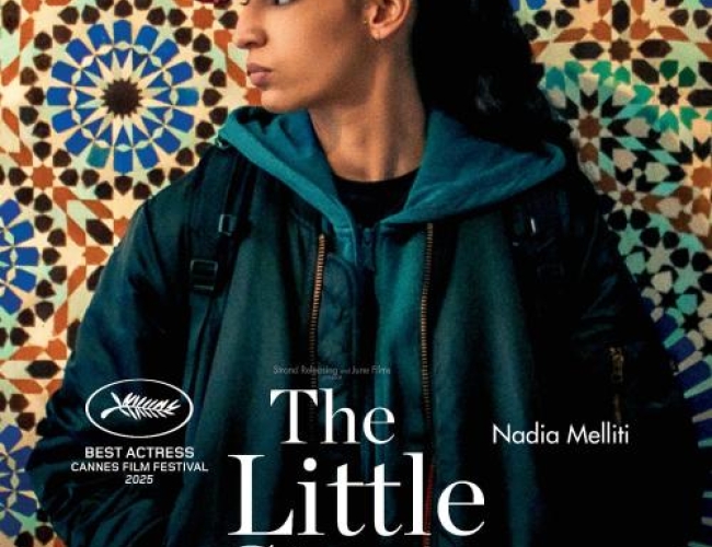 Image of the main actress from the film standing in front of a mosaic background.