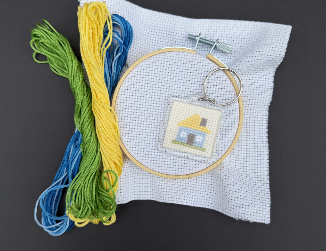 An image of embroidered keychain (Ukrainian house) and materials