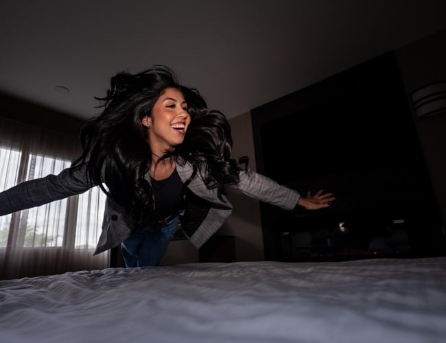 Girl Jumping onto Bed at Park Town Hotel