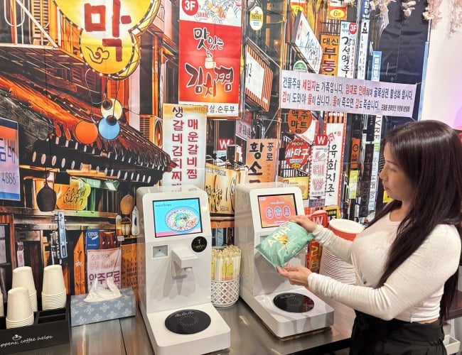 Young Lady scanning a bag of ramen on a ramen machine