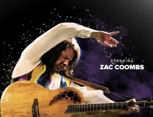 Image of tribute impersonator Zac Combs as Neil Diamond, posing with a guitar and smoke behind him.
