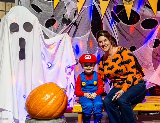 People in costume getting their picture taken with a ghost