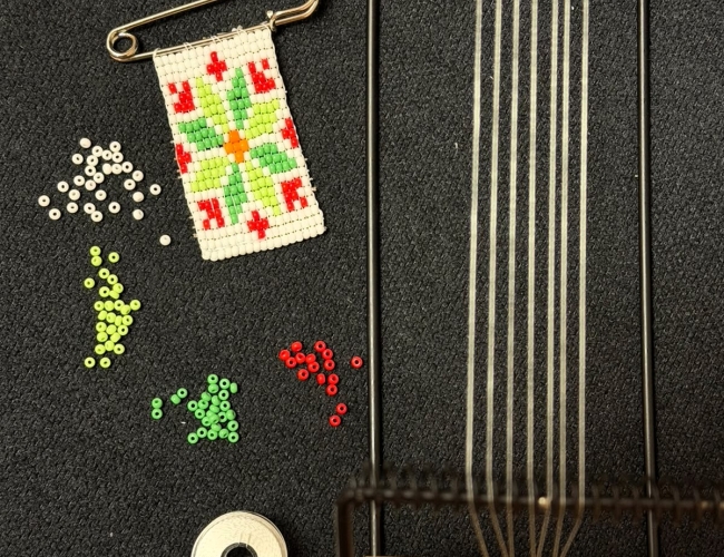 Staged photo of the final product (cotillion), beads, thread, and bead loom