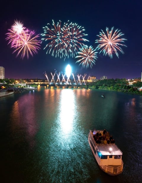 Fireworks at night, exploding over the city skyline of Saskatoon