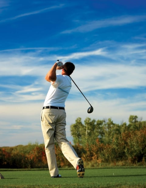 man teeing off on a golf course
