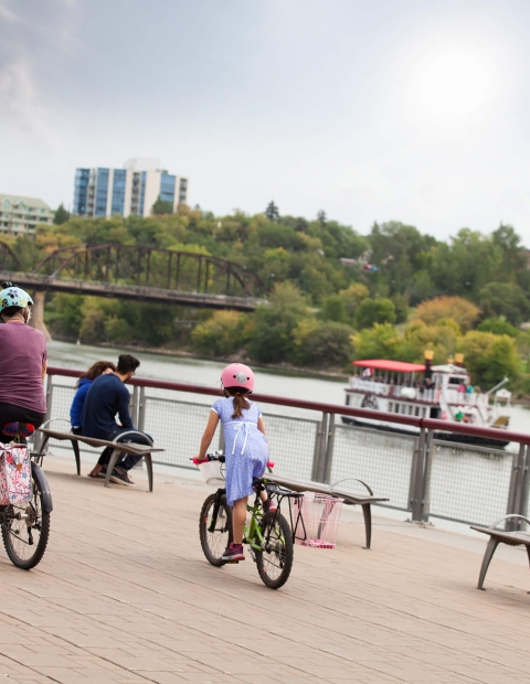 Family on bicycles cycling by the water