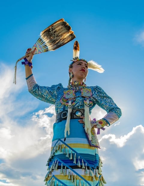 An Indigenous woman in traditional beaded clothing